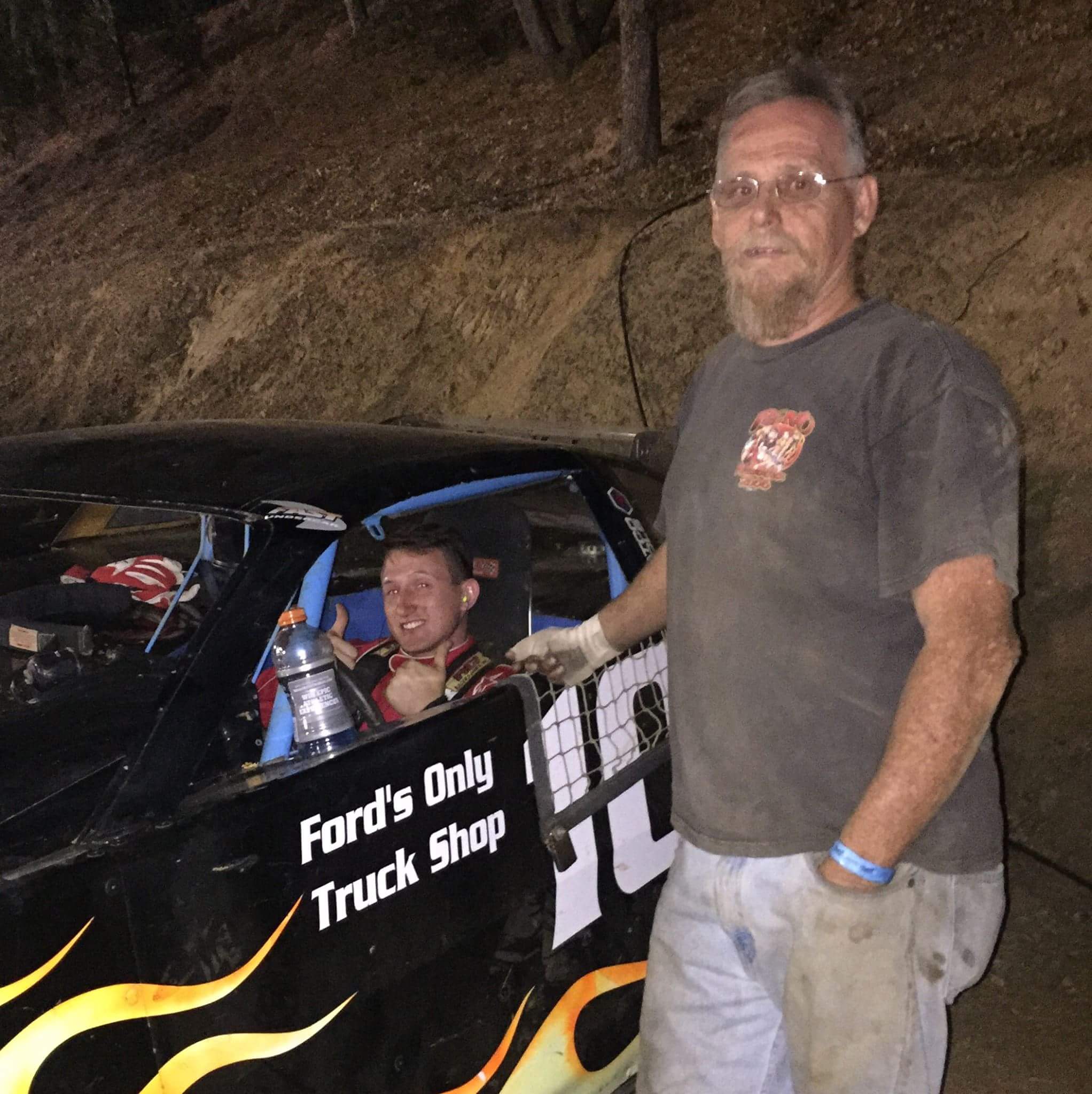 Bryan at the track beside a driver in the car